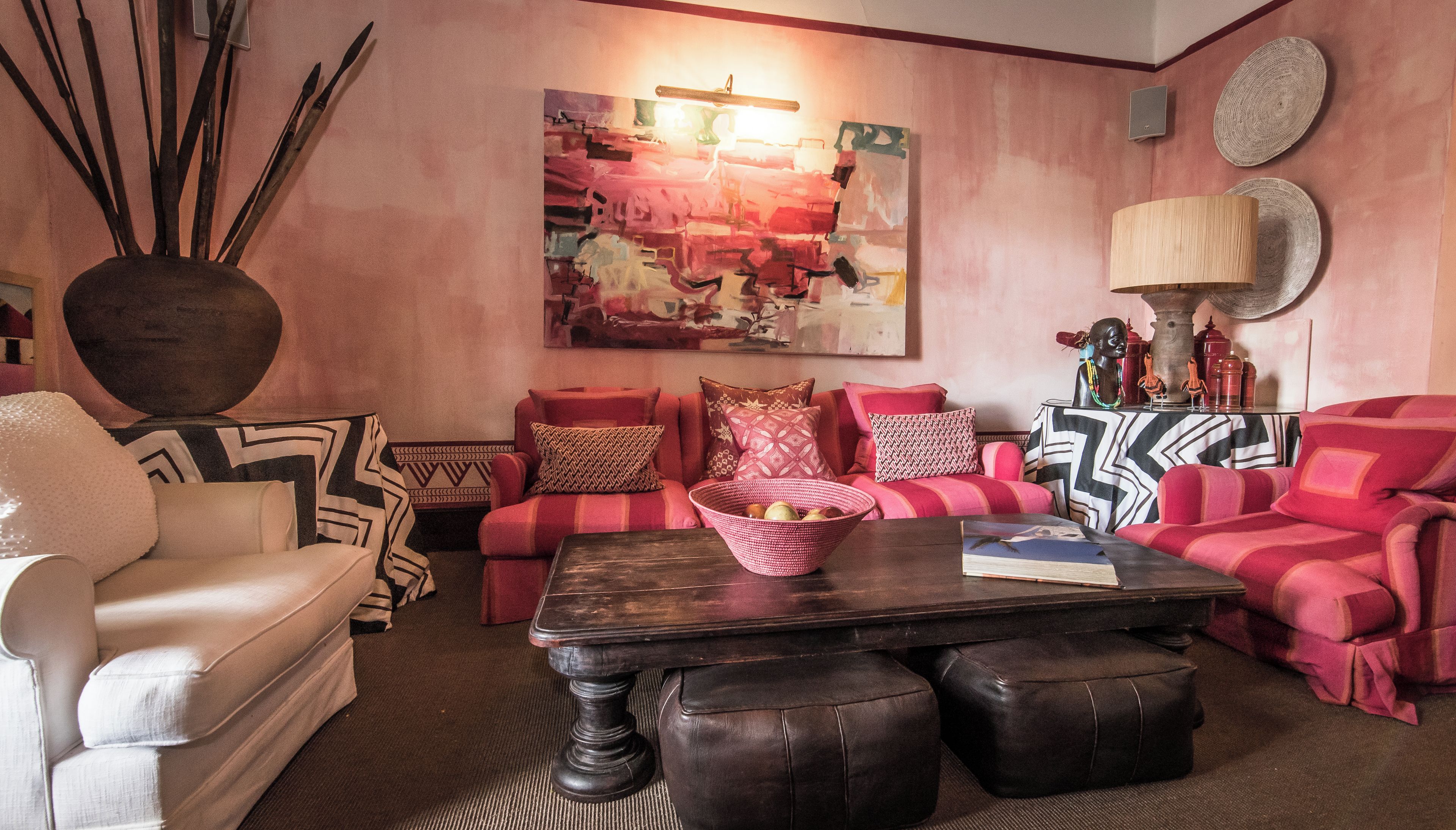 Una sala de estar con un sofá, una mesa de centro y un jarrón decorativo.