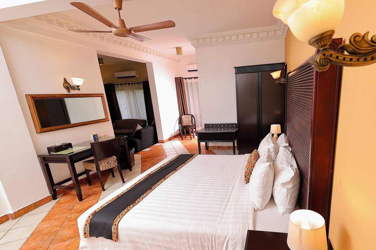 A hotel room with a bed, desk, chair, and wardrobe.