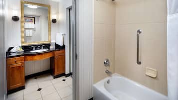 A modern bathroom with a sink, mirror, and bathtub.