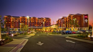 A hotel with multiple buildings, a parking lot, and a well-lit entrance. - Homewood Suites by Hilton Rockville-Gaithersburg (Rockville)