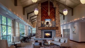 A spacious lobby with a stone fireplace, comfortable seating, and large windows. - Homewood Suites by Hilton Rockville-Gaithersburg (Rockville)