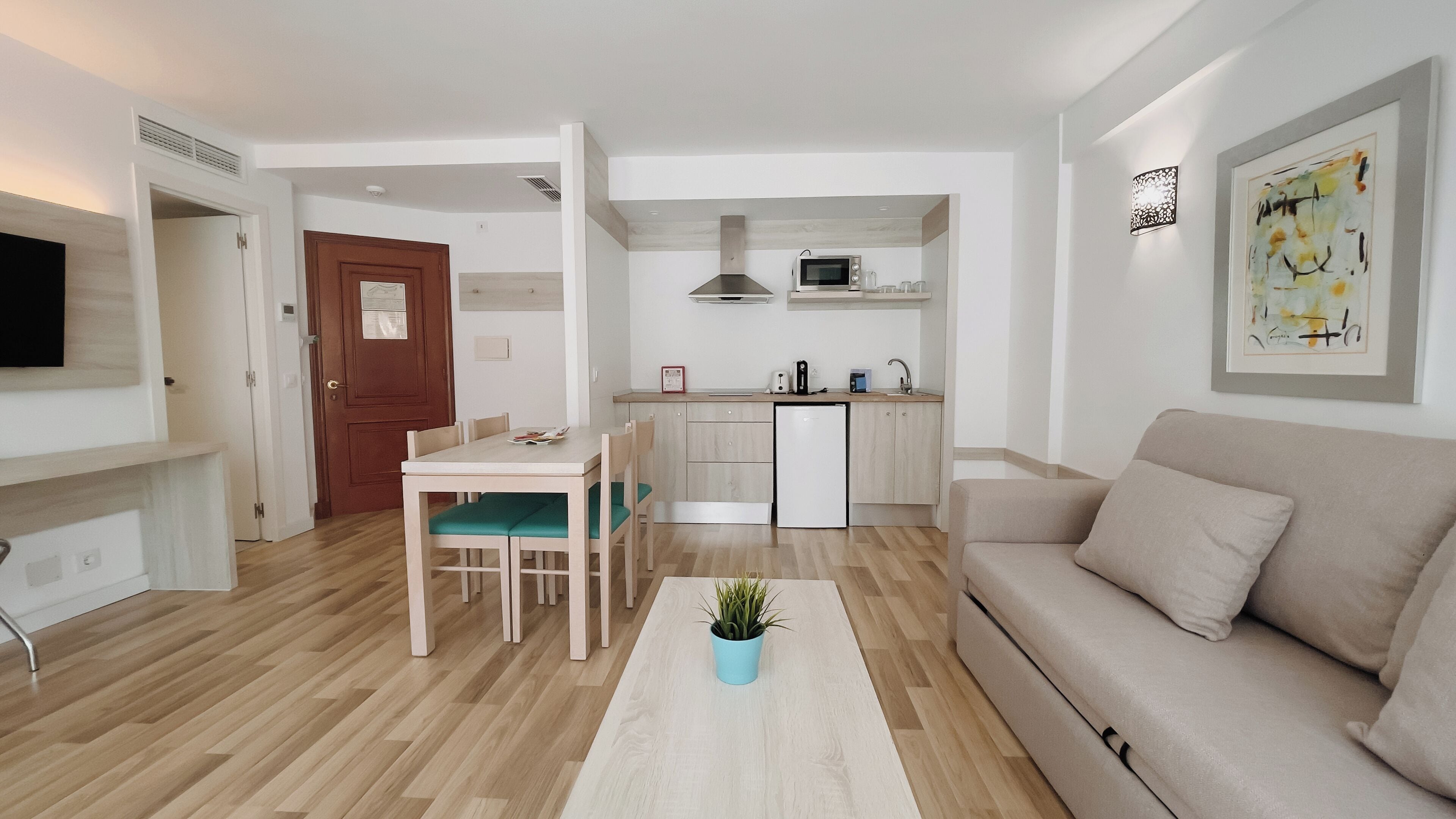 Eine moderne Wohnung mit Essbereich, Küchenzeile und Wohnzimmer.