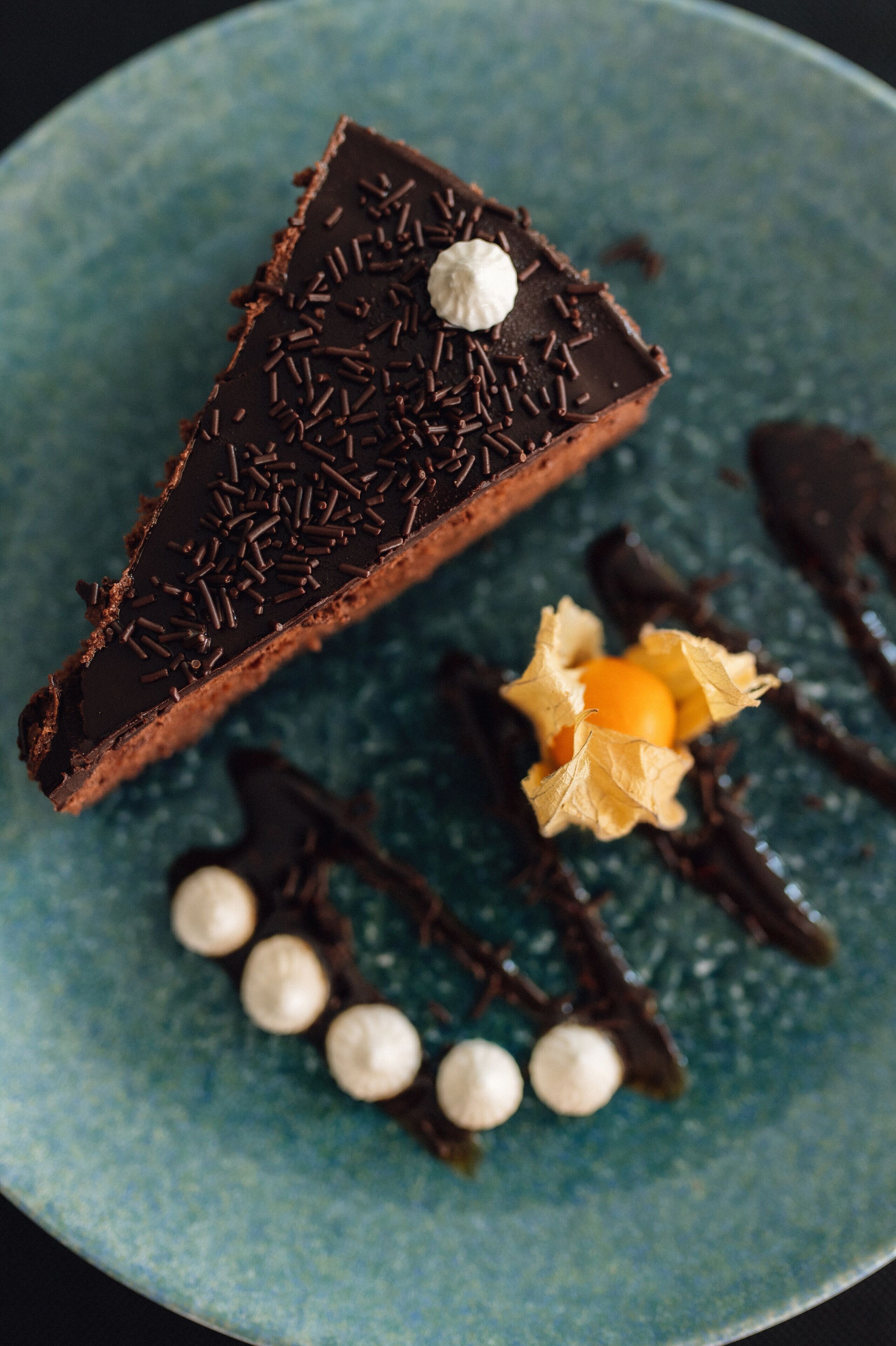 A dessert with chocolate and sprinkles on a blue plate.