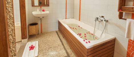 A bathroom with a bathtub, a sink, and a mirror.