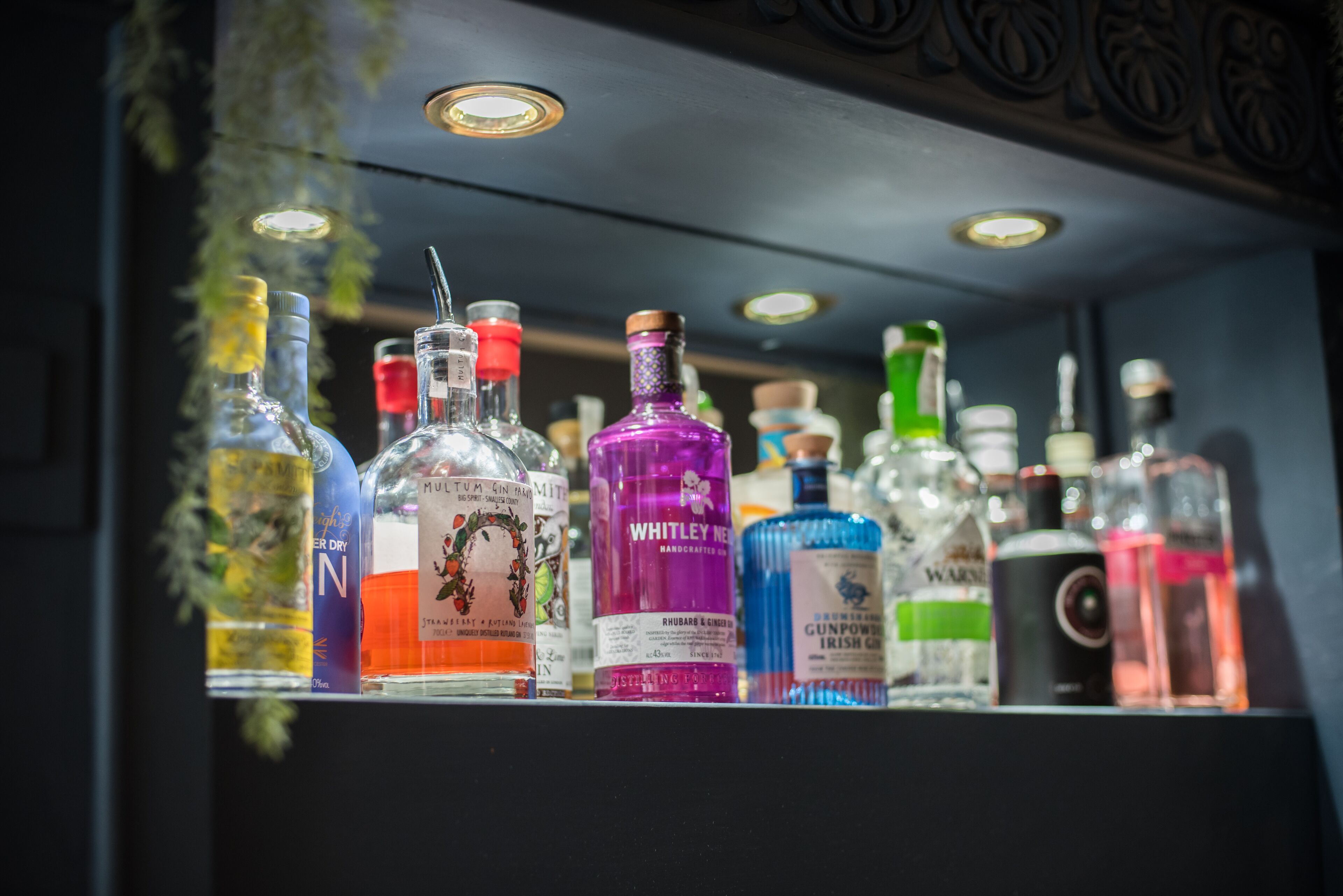 Un comptoir de bar avec différentes bouteilles d’alcool.