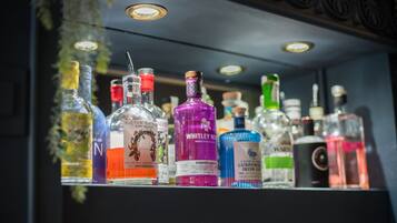 A bar shelf with various bottles of alcohol.
