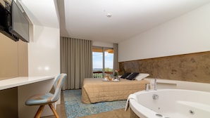 A modern hotel room with a bed, a desk, a chair, a large bathtub, and a view of the outdoors. - Do Parque - Viana do Castelo (Viana do Castelo)