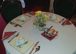 Enjoy a formal dining experience at Georgian House Hotel, where a beautifully set table awaits with fine tableware and a lovely centerpiece.