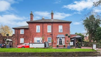 A red brick building with a signboard indicating it is a hotel.