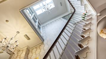 Eine prachtvolle Treppe mit weißen Balustraden und einem Kronleuchter.