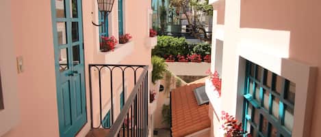 A narrow alleyway with a staircase, a blue door, and a lantern.