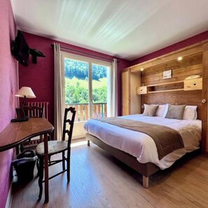 Un dormitorio con una cama, una mesa y una silla.