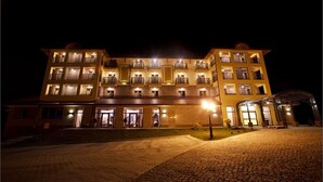 Ein mehrstöckiges Hotel mit Innenhof, Balkonen und einem überdachten Eingang.