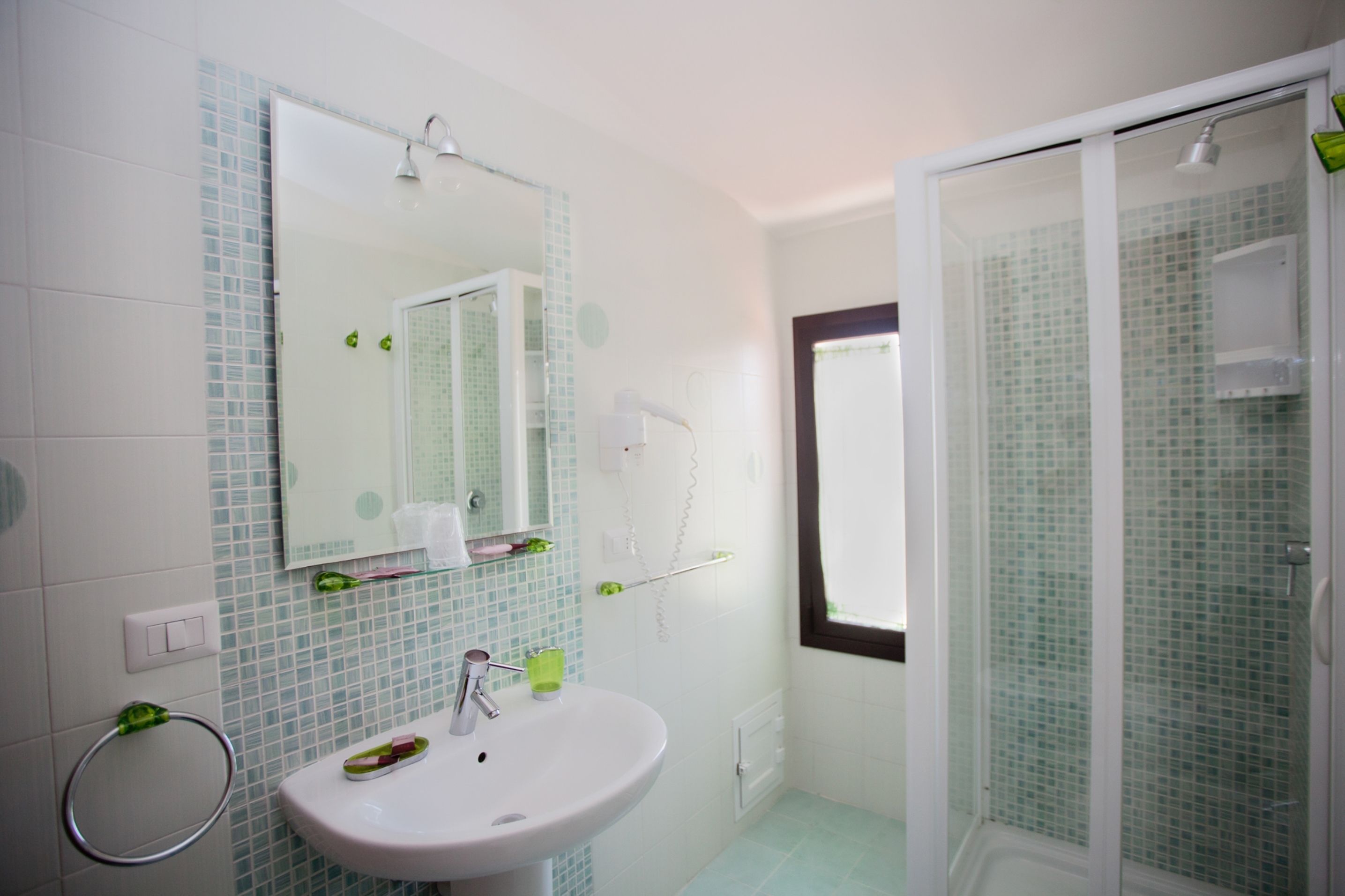 Un bagno con lavandino, specchio e zona doccia.