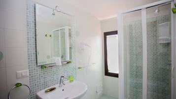 Un bagno con lavandino, specchio e zona doccia.