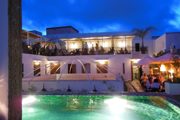 Una piscina al aire libre, sombrillas, tumbonas