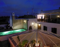Un área de piscina en la azotea con vistas despejadas de los edificios circundantes y una torre distante.