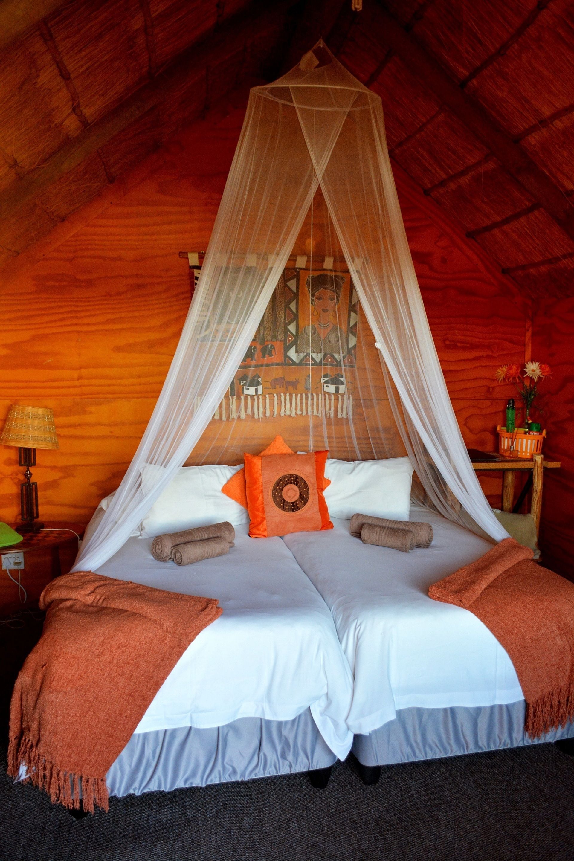 Een bed met hemelbed, kussens en een deken.