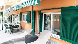 A patio with a table and chairs, a small round table, and a lounge chair. - Rex Hotel Residence (Genoa)