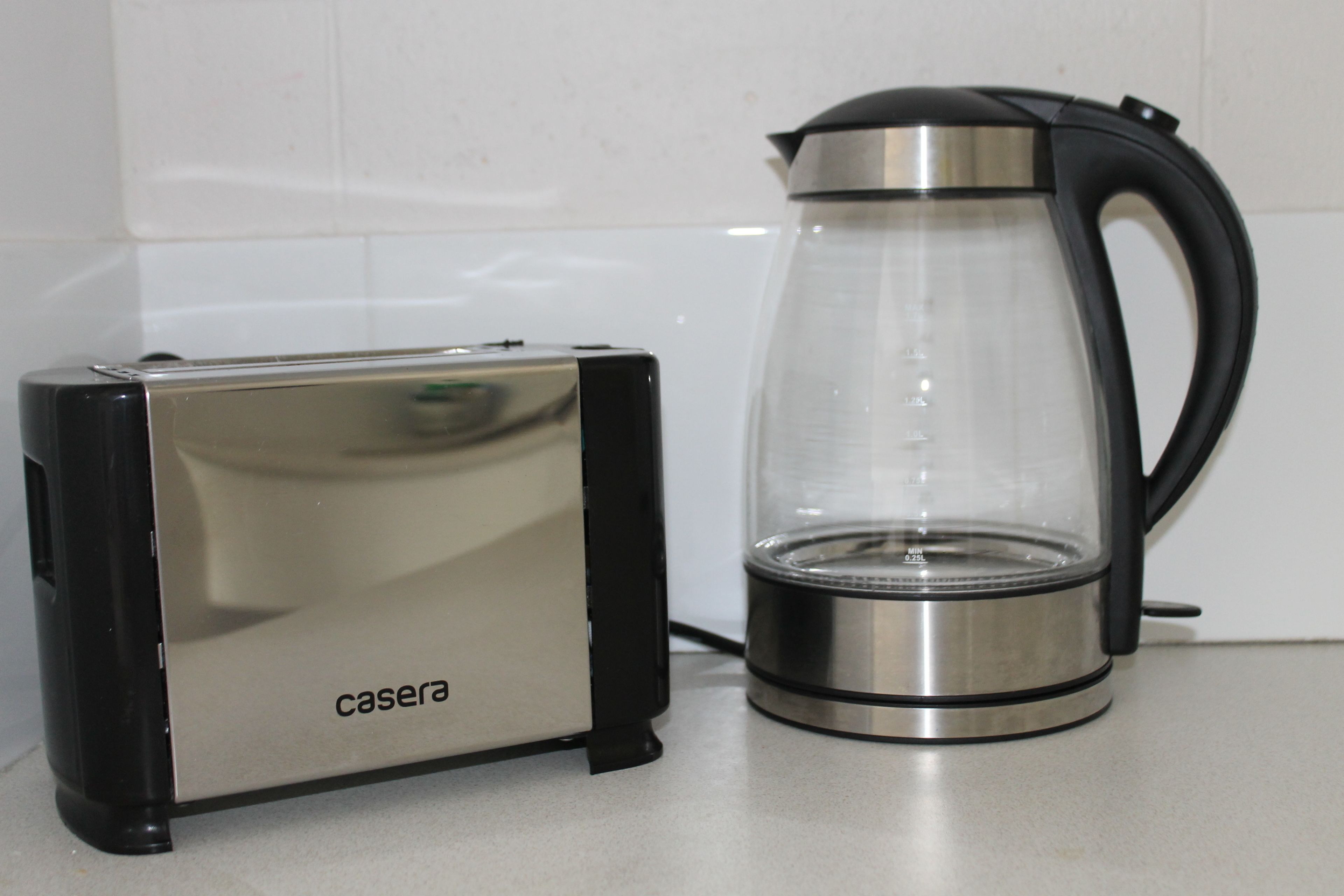 Una cocina con un tostador y una cafetera de vidrio sobre la encimera.