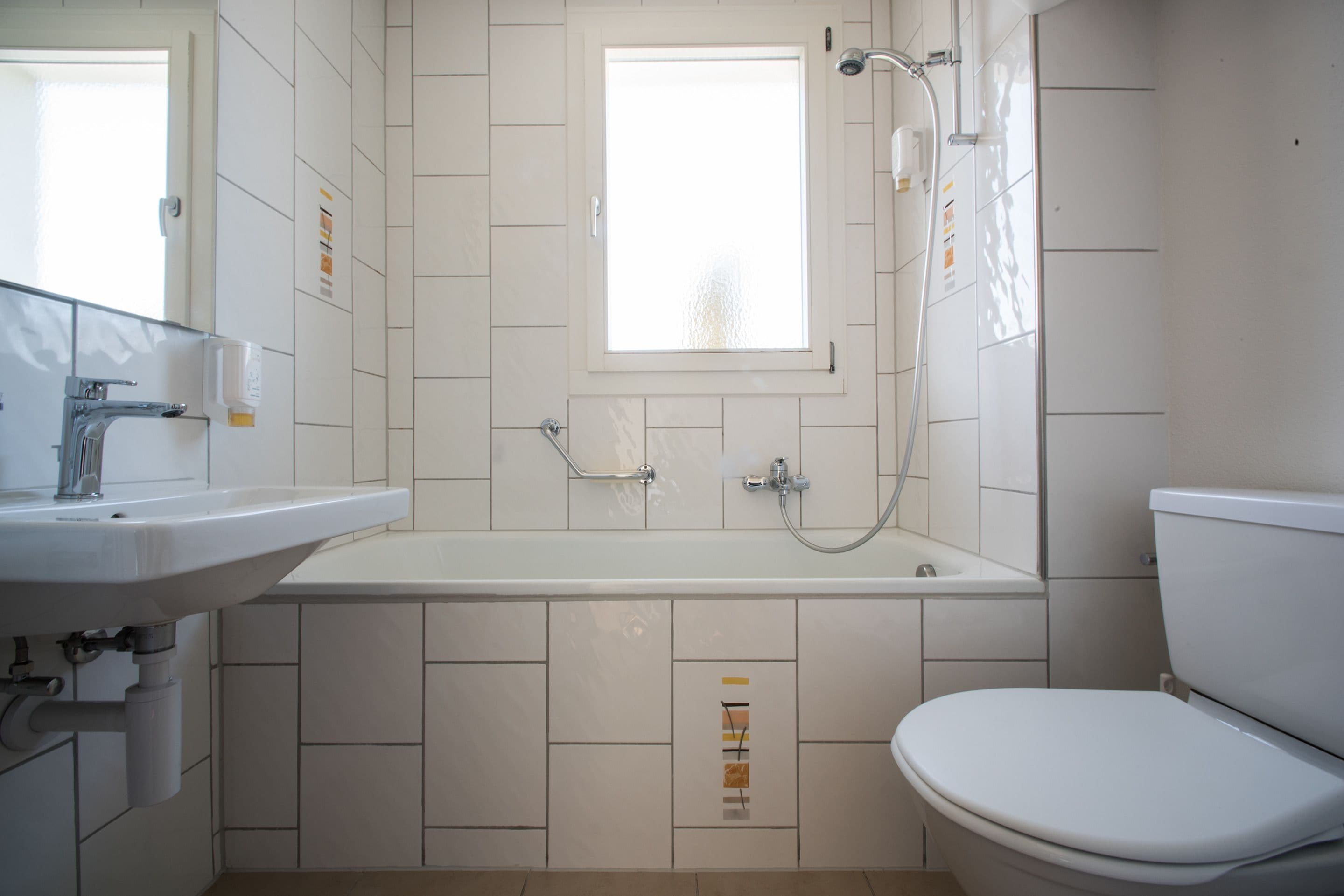 A bathroom with a white sink, a bathtub, and a toilet.