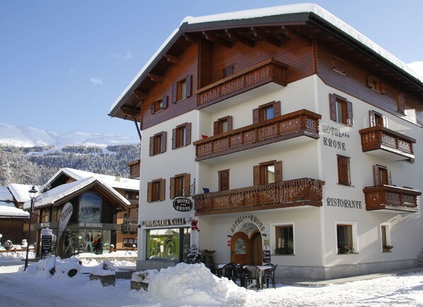 Un hôtel doté de nombreux balcons, d’un restaurant et d’une enseigne indiquant qu’il s’agit d’un hôtel.