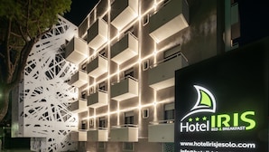 Um hotel moderno com fachada geométrica e varandas iluminadas.