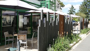 A restaurant named "La Cohue" with outdoor seating and a wooden fence. - Le Champalud (Orée d'Anjou)