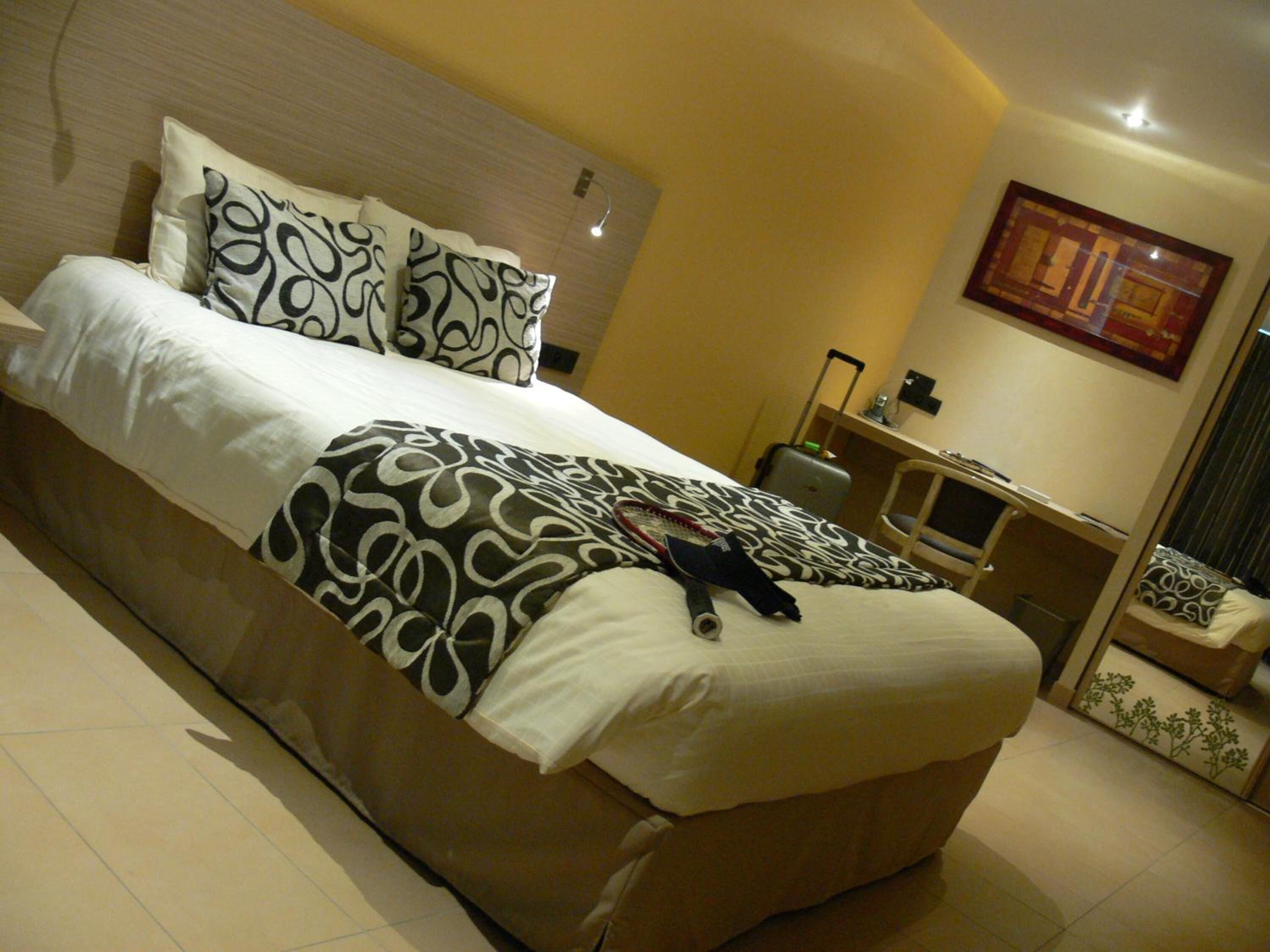 Una habitación de hotel con una cama grande, un escritorio y una silla.