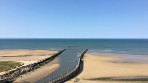 A coastal road leading to a beach with a long pier extending into the sea. - Hôtel restaurant La pêcherie (Courseulles-sur-Mer)