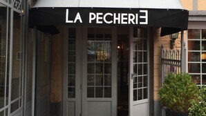 The entrance of La Pecherie hotel with a black awning and a sign above the doors. - Hôtel restaurant La pêcherie (Courseulles-sur-Mer)