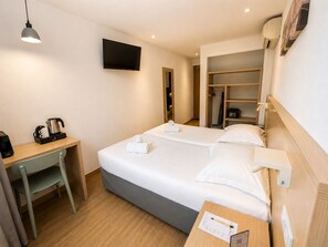 A hotel room with a bed, a desk, a TV, and a wardrobe. - Hôtel Holzer II (Porto-Vecchio)