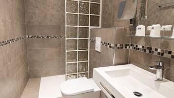 Ein modernes Badezimmer mit Dusche, Toilette und Waschbecken.