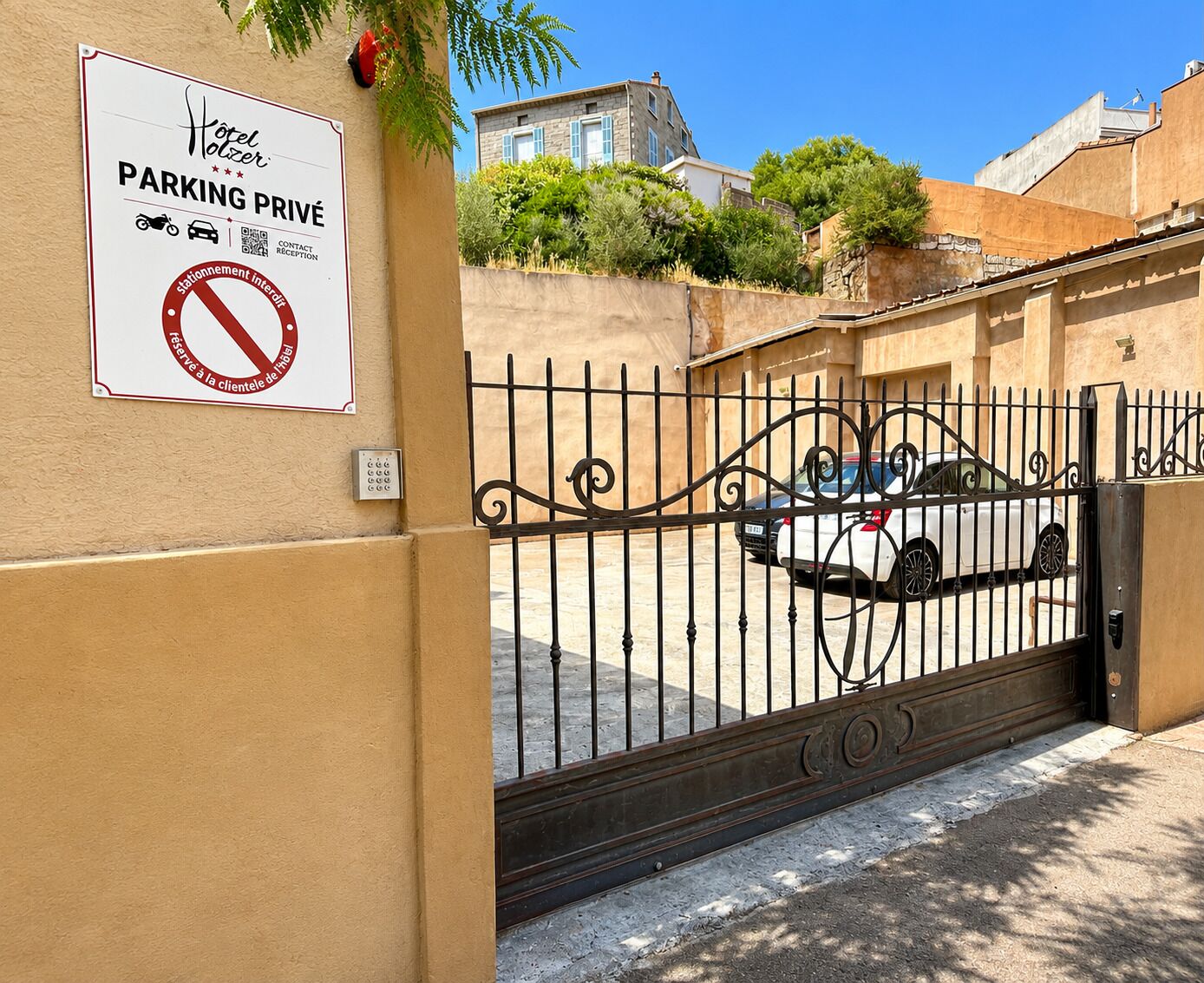 A gated entrance to a hotel with a sign indicating private parking.