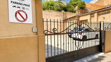 A gated entrance to a hotel with a sign indicating private parking.