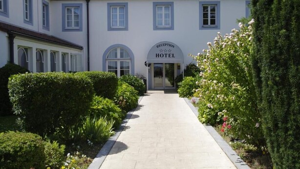 A reception area of a hotel with a clear pathway leading to the entrance. - Les Tuileries (Fey)