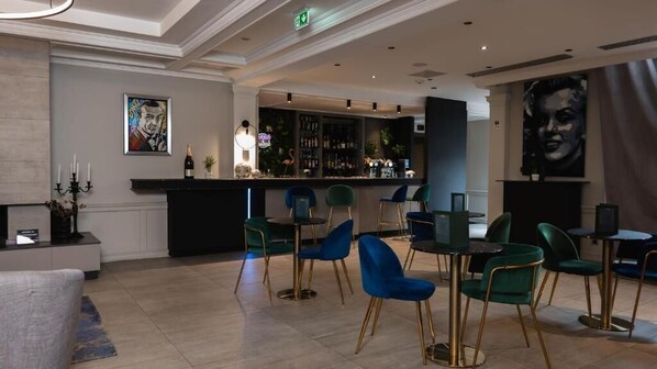 A bar area with a counter, bar stools, and a seating area with chairs. - Les Tuileries (Fey)