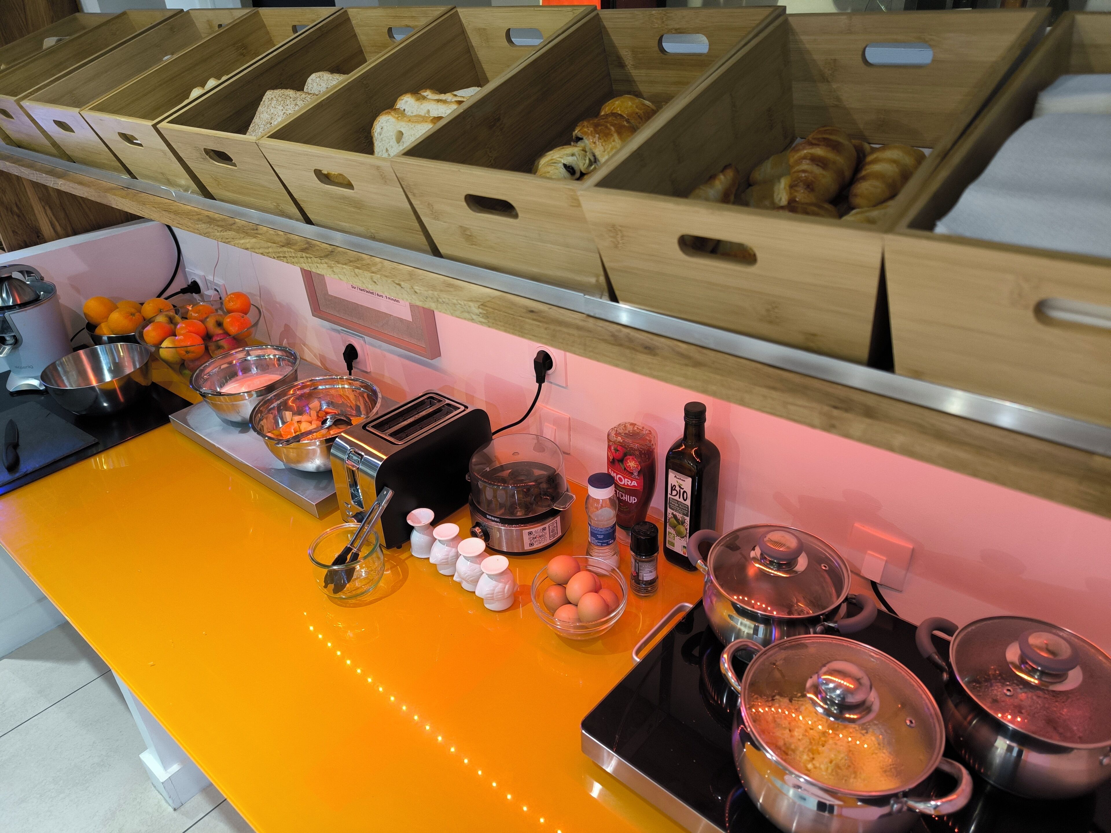 Una encimera de cocina con diversos alimentos, un tostador y ollas de cocina.