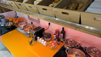 Una encimera de cocina con diversos alimentos, un tostador y ollas de cocina.