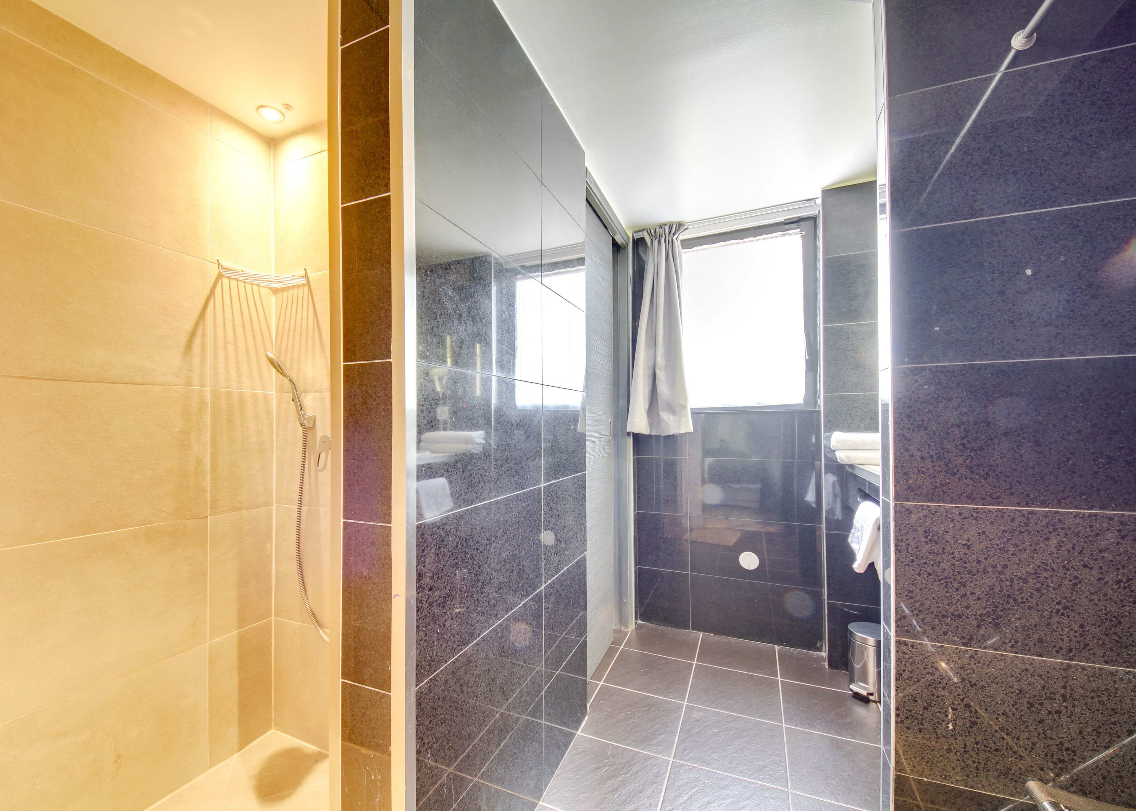 A modern bathroom with a shower, a toilet, and a sink.