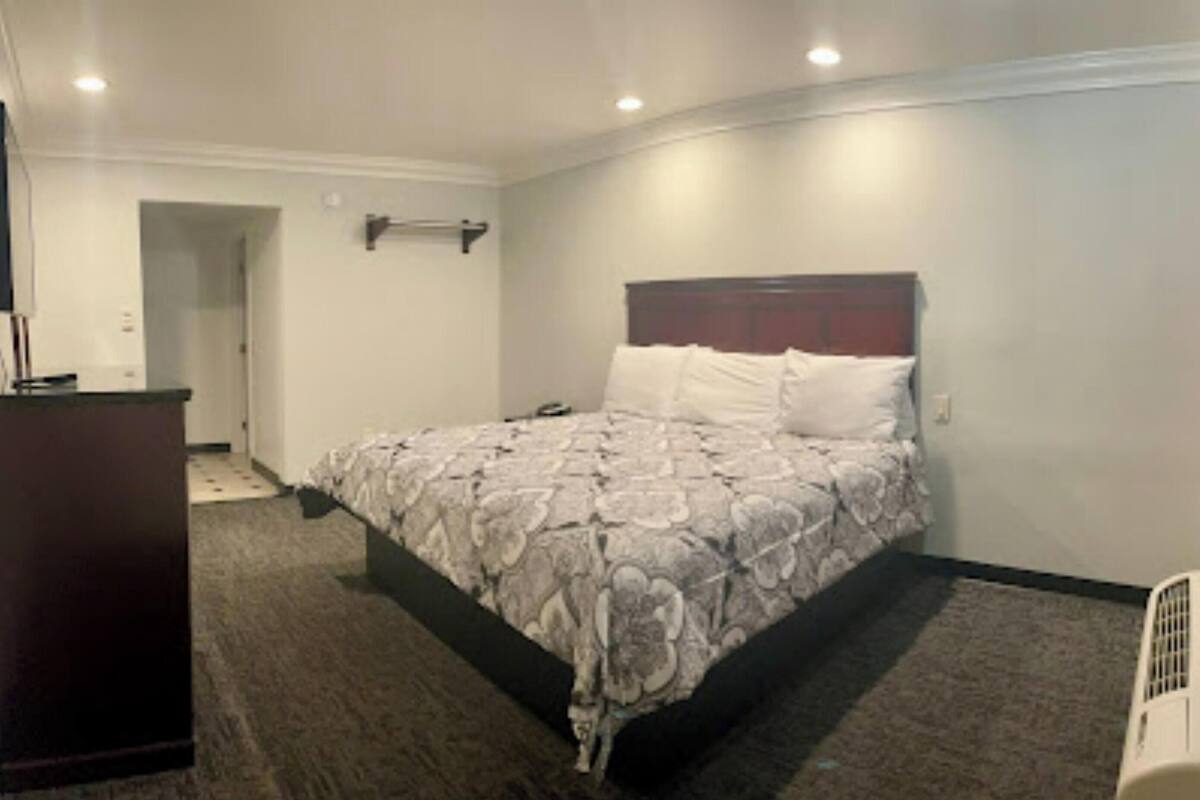 Een hotelkamer met een bed, een kaptafel en een inloopkast.