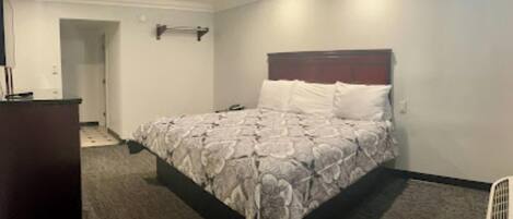 Una habitación de hotel con cama, cómoda y vestidor.