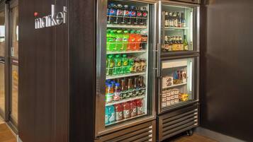 Un refrigerador con exhibición de bebidas y aperitivos varios.