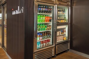 A refrigerated display case in a store with various beverages and snacks.
