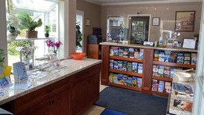 Una habitación luminosa con un ventanal grande, armarios de madera y una encimera con varios libros y objetos.