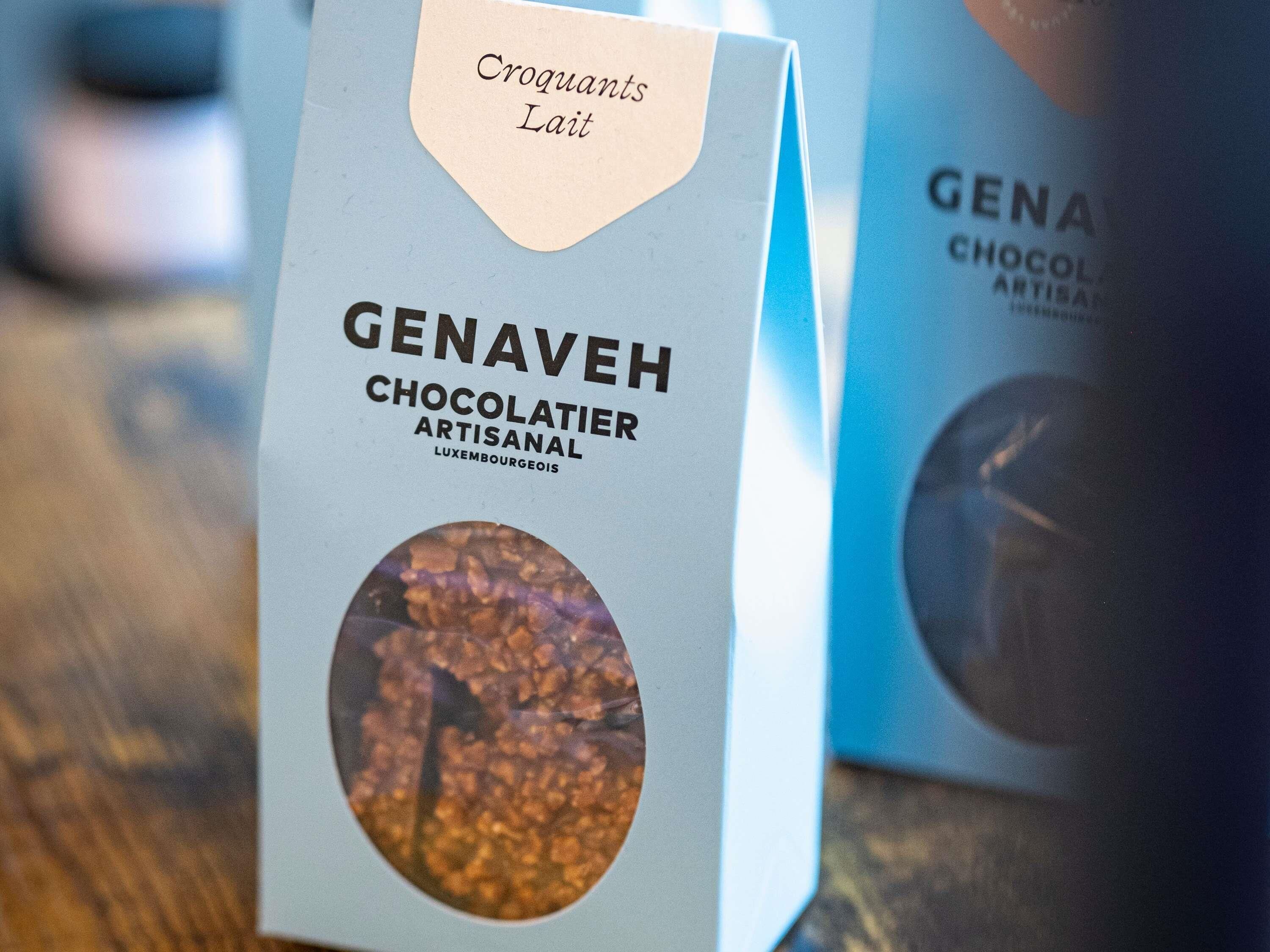 Una caja de bombones artesanales Genaveh Chocolatier con una imagen circular de chocolate en la parte frontal.