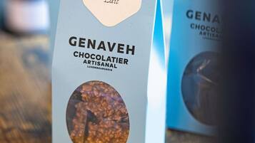 Una caja de bombones artesanales Genaveh Chocolatier con una imagen circular de chocolate en la parte frontal.