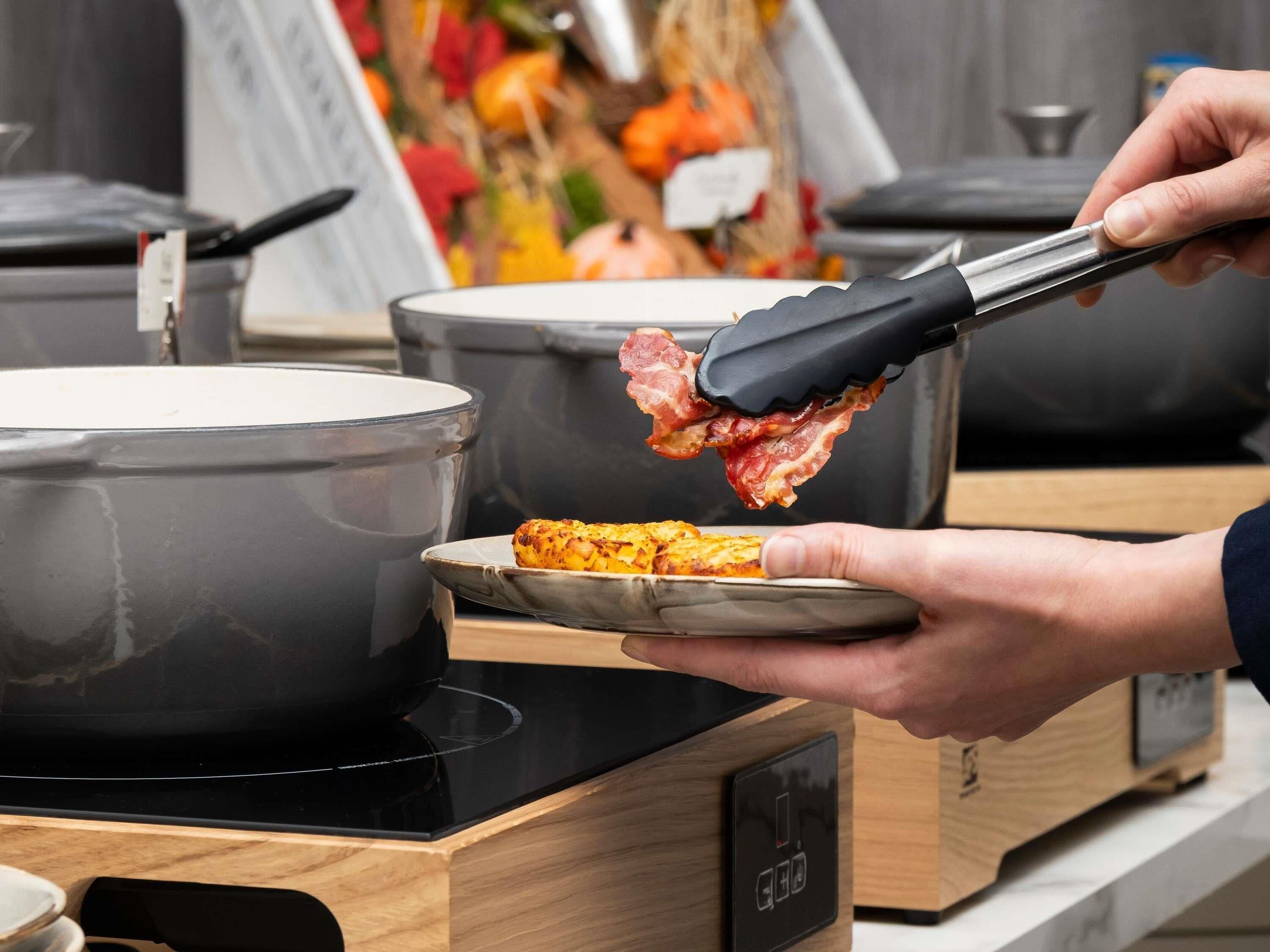 Une personne utilise des pinces pour servir de la nourriture d’une casserole à une assiette.
