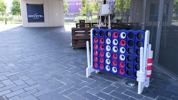 Un tablero azul y blanco con agujeros, un banco de madera y un letrero de Novotel.