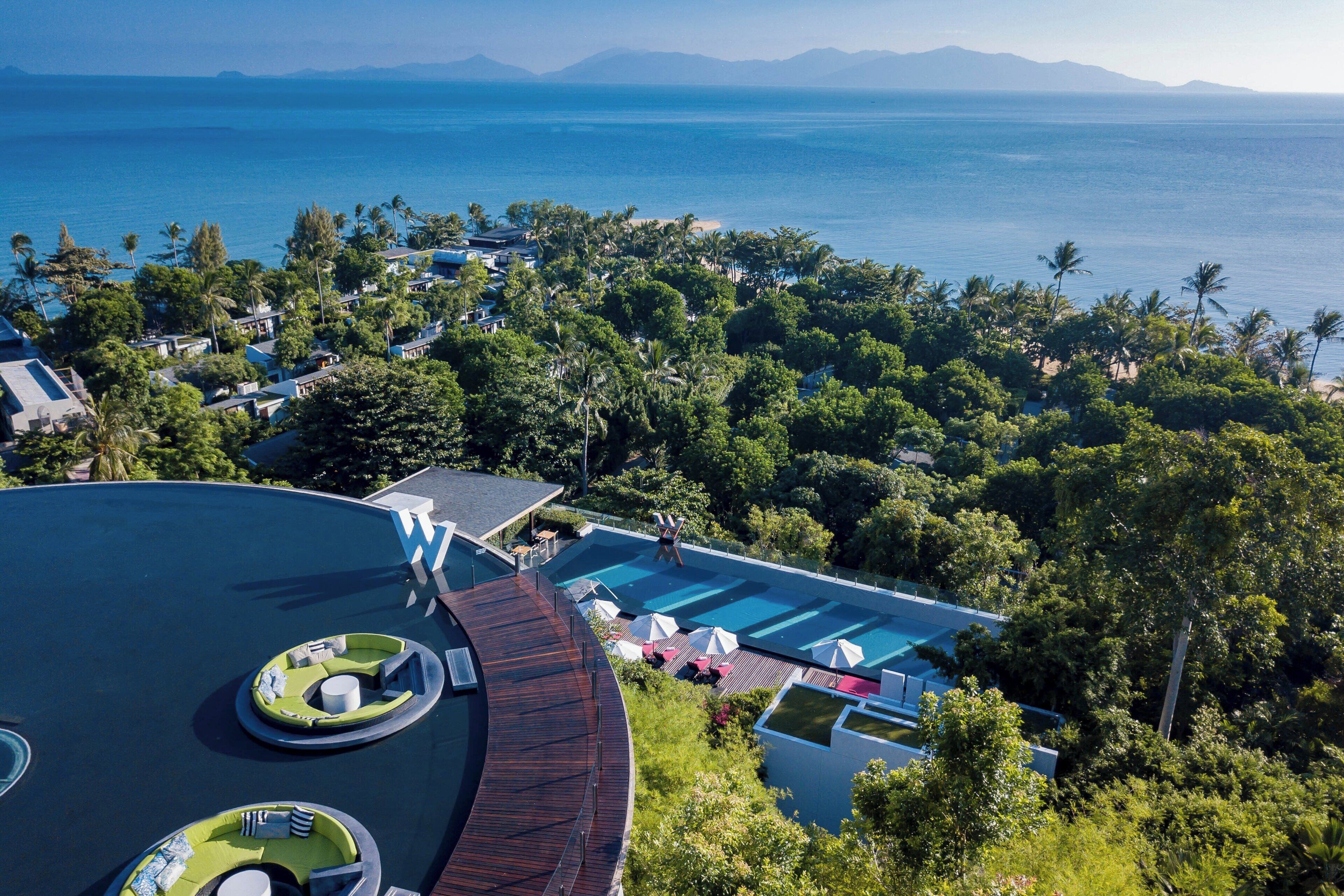Un complexe hôtelier doté d’une grande piscine, d’une végétation luxuriante et offrant une vue sur l’océan.